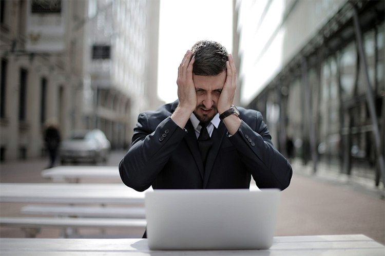 Man Unfocused And Frustrated Looking at Laptop